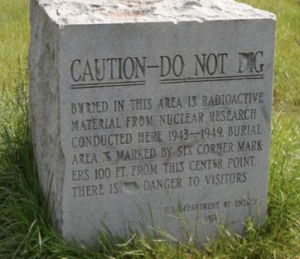 Mixed messages: A simple stone marker in Red Gate Woods, just outside Chicago, tries to both warn and reassure visitors to this public park. (Photo: Kevin Kamps, Beyond Nuclear. Used by permission.)